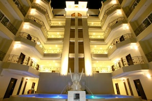 A multi-story hotel with a central atrium, balconies, and a statue. - LK Residence (Pattaya)