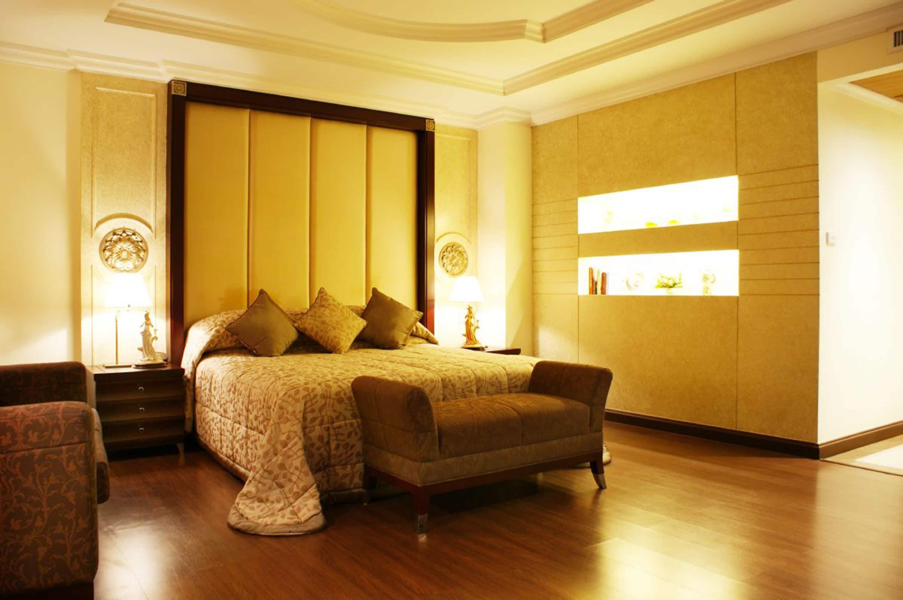 Une chambre d’hôtel avec un grand lit, un canapé et une table de chevet avec une lampe.