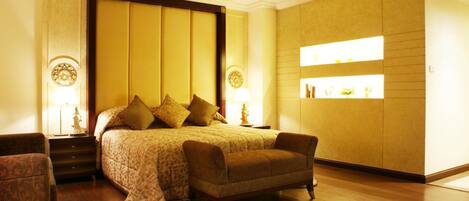 Une chambre d’hôtel avec un grand lit, un canapé et une table de chevet avec une lampe.