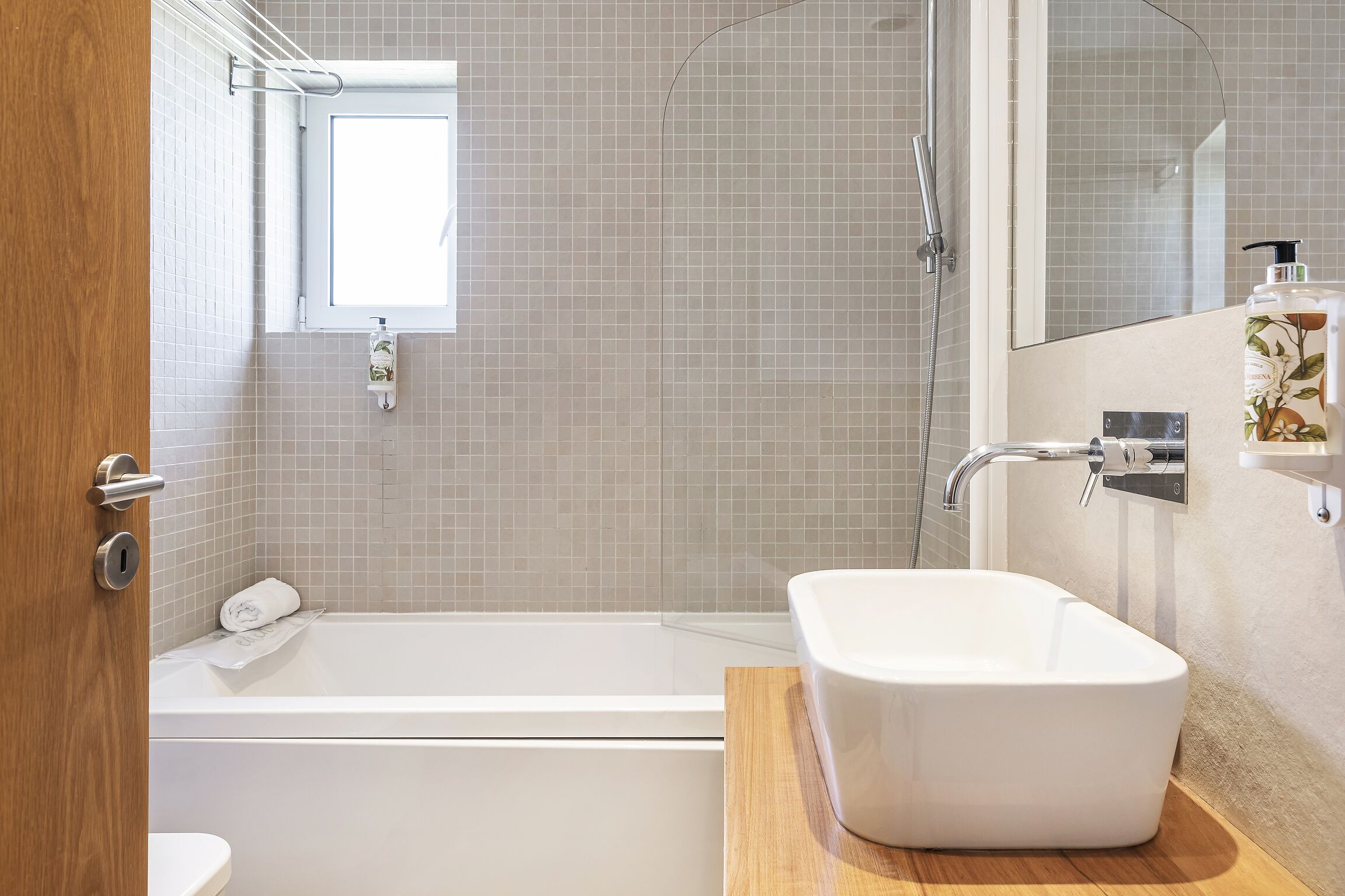 Une salle de bain moderne avec une baignoire, une douche et un grand miroir.