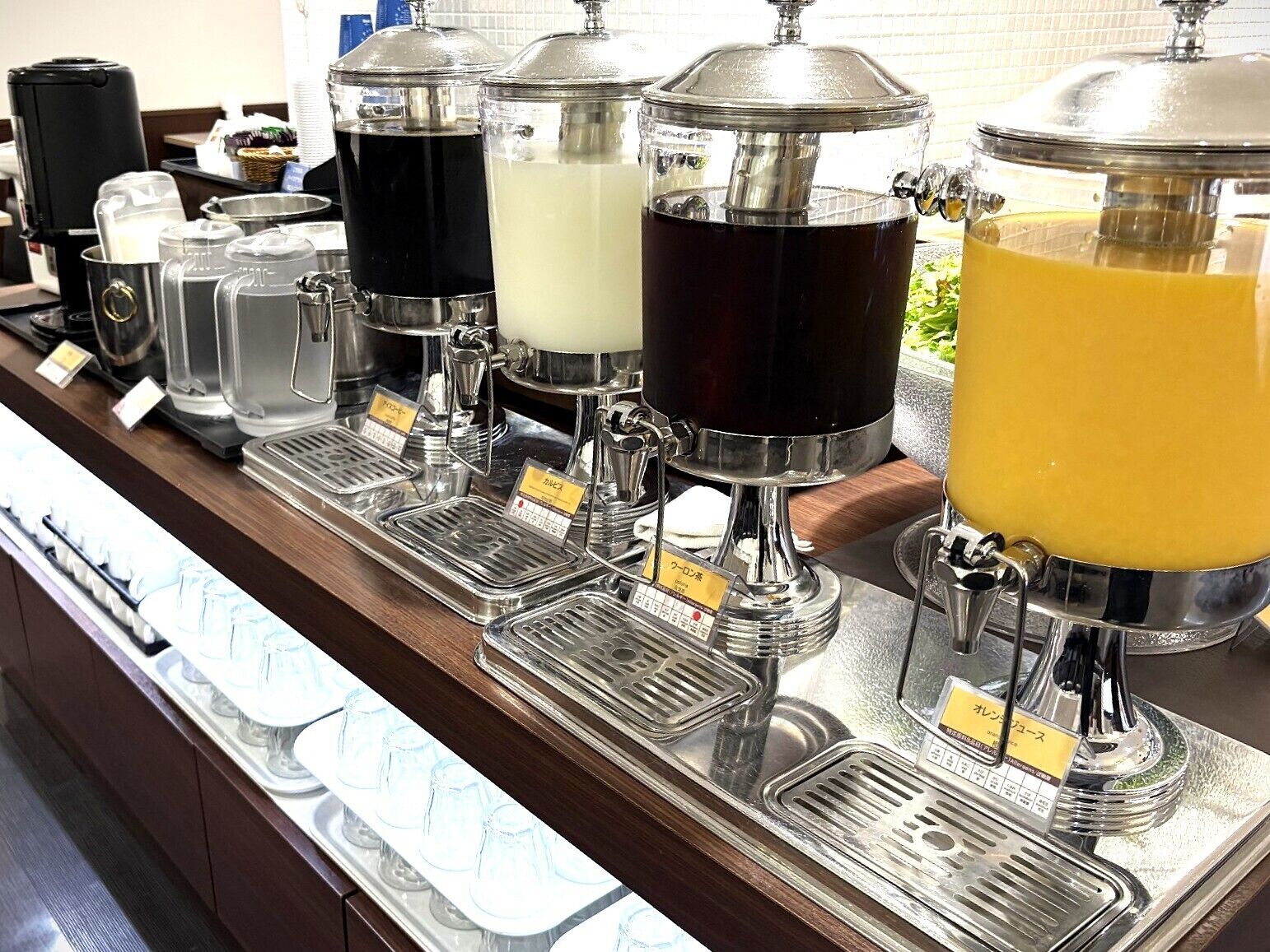 A beverage station with multiple dispensers, each labeled with a different drink.