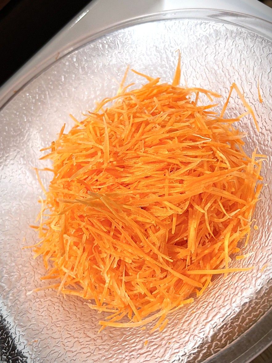 A clear glass bowl filled with shredded orange material.