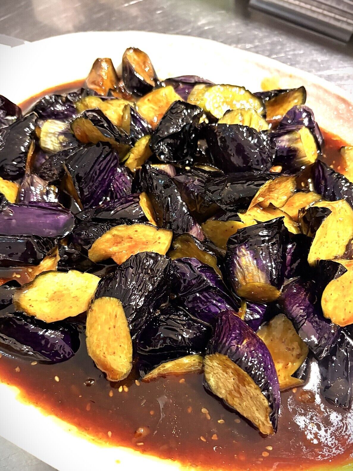 Primer plano de rodajas de berenjena asada con salsa brillante.