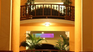 A grand lobby with a double balcony, large potted plants, and a chandelier. - Fortune Resort Benaulim Goa - Member ITC Hotels' Group (Benaulim)