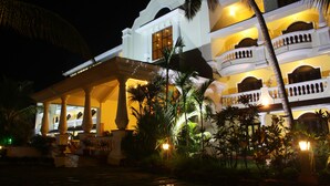 A multi-story hotel with balconies, columns, and a well-lit entrance. - Fortune Resort Benaulim Goa - Member ITC Hotels' Group (Benaulim)