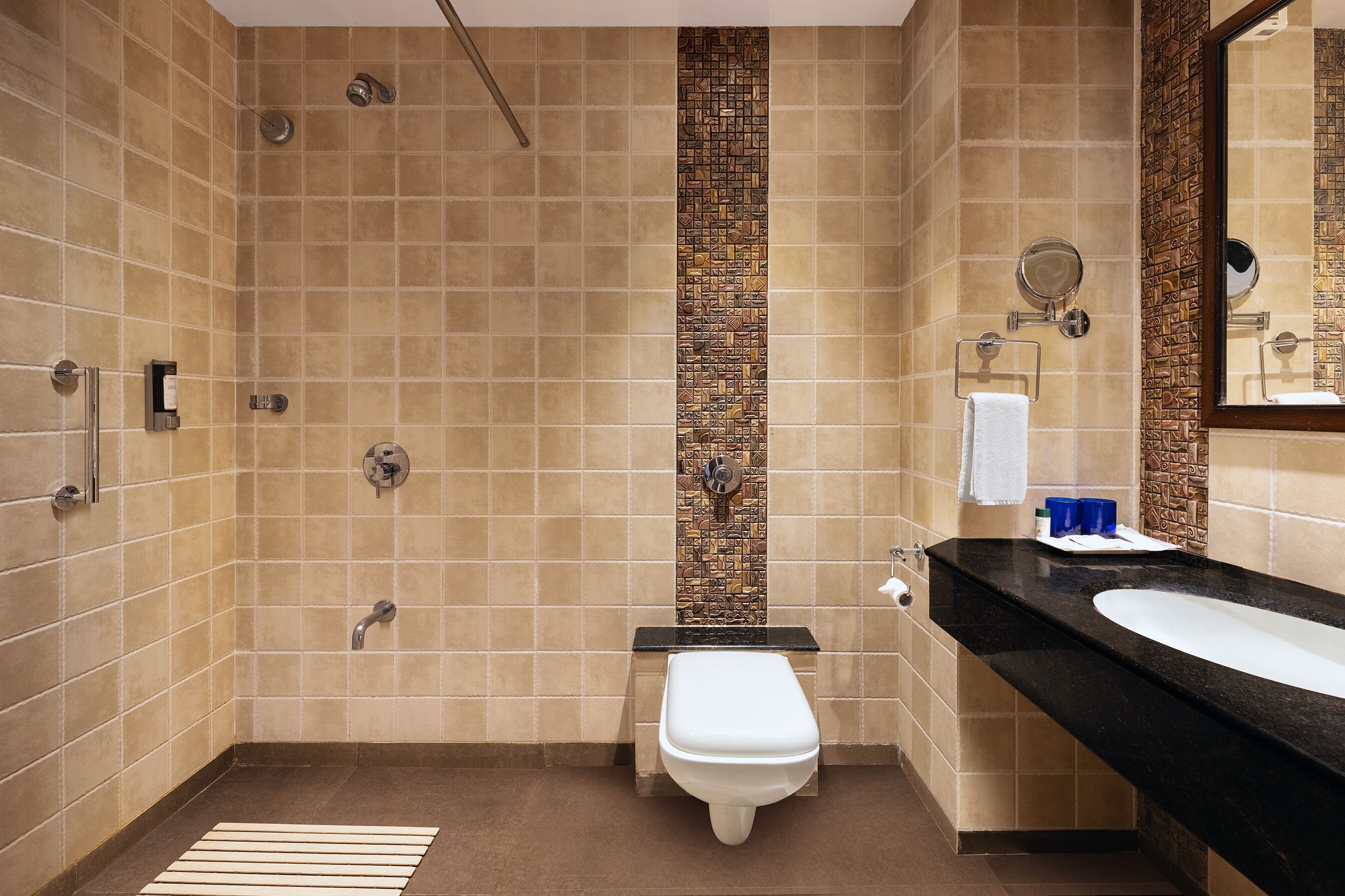 A bathroom with a shower, toilet, and sink.