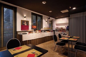 Un'area pranzo moderna con un'attrezzatura per buffet, diversi tavoli e sedie.