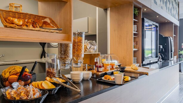 A breakfast buffet with various pastries, fruits, and beverages. - B&B HOTEL Béthune Bruay-la-Buissière (Bruay-la-Buissiere)