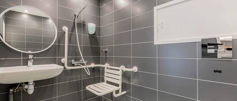 A modern bathroom with a white sink, mirror, and toilet.