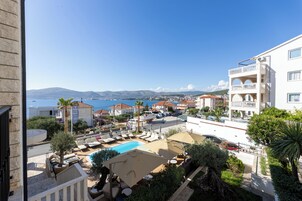 Un resort con piscina, sillas de descanso y vistas al mar.
