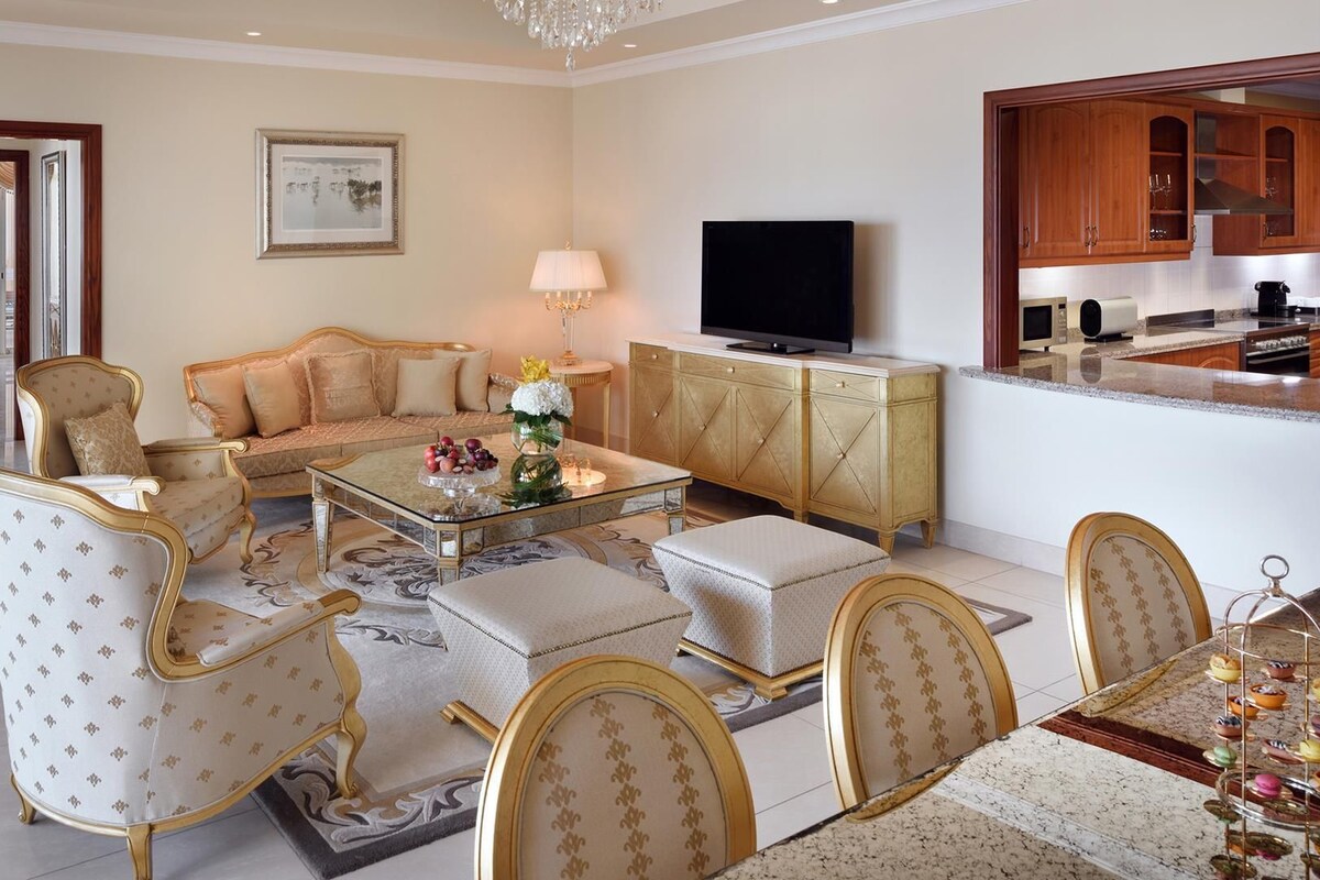 Un salón amplio con un sofá, sillones, una mesa de centro y una televisión.