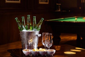 A bar area with a pool table and a bucket of champagne bottles.