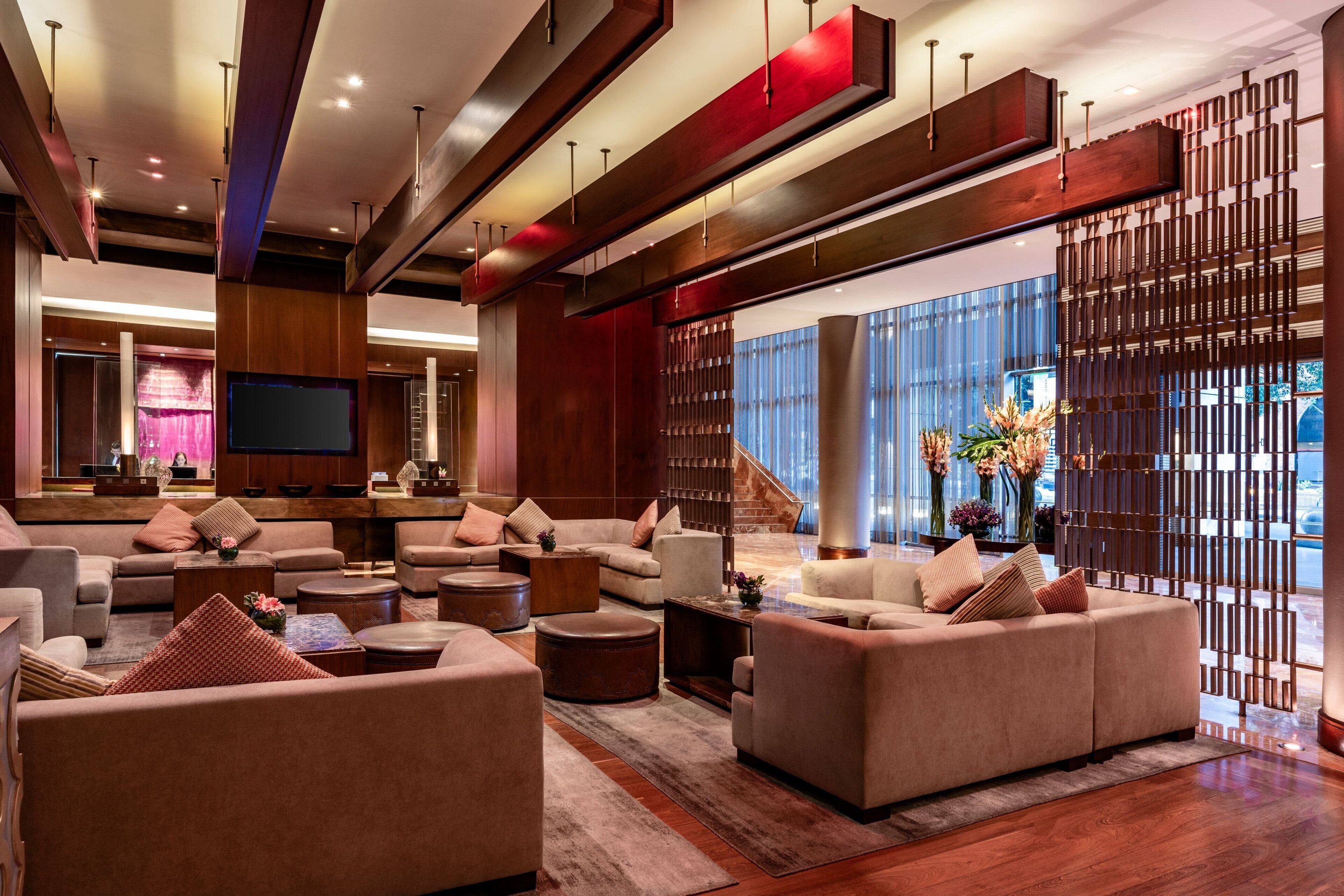 A spacious lobby with modern furnishings, a staircase, and large windows.