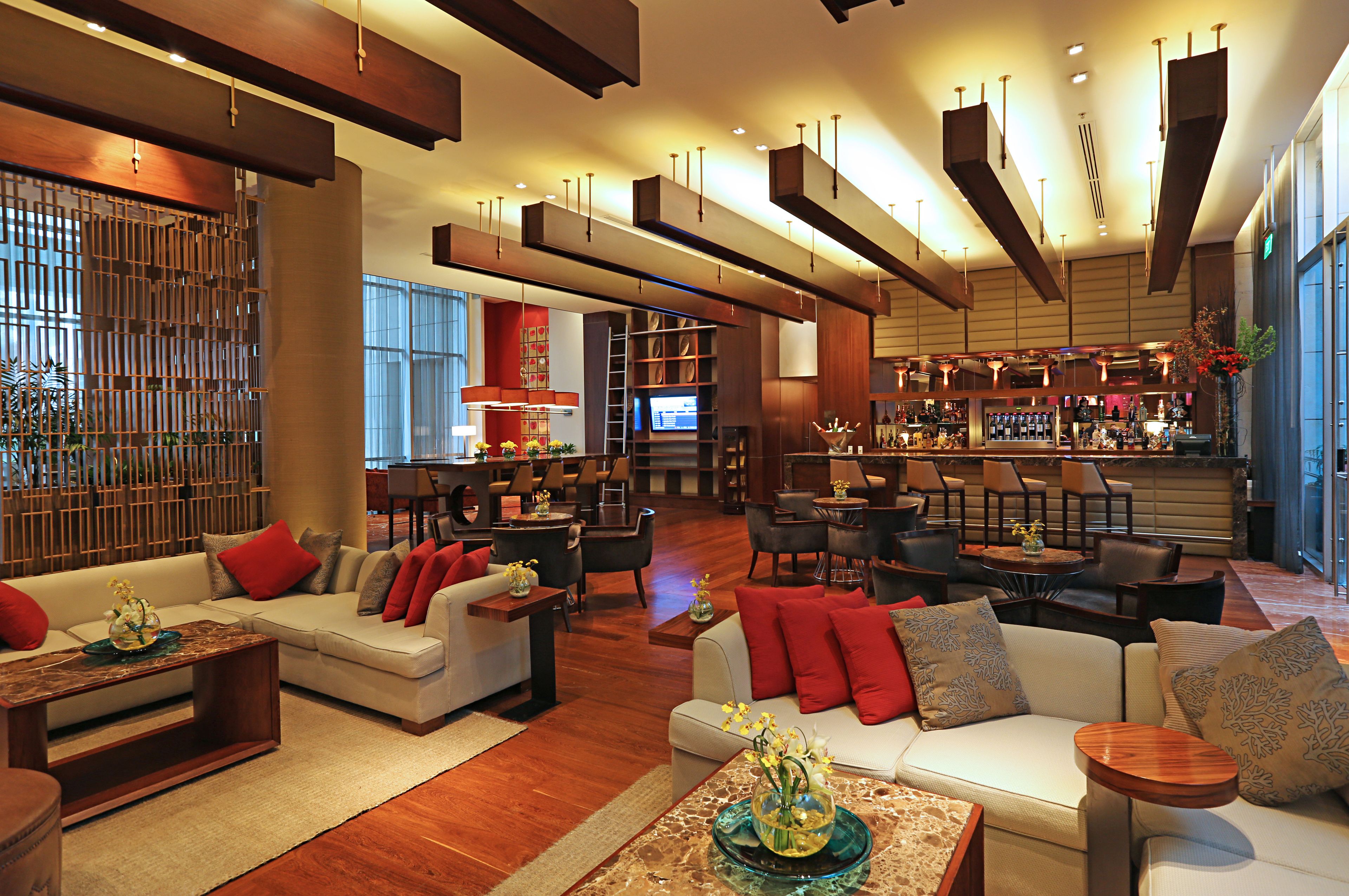 A spacious lobby with a bar area, seating arrangements, and a modern design.