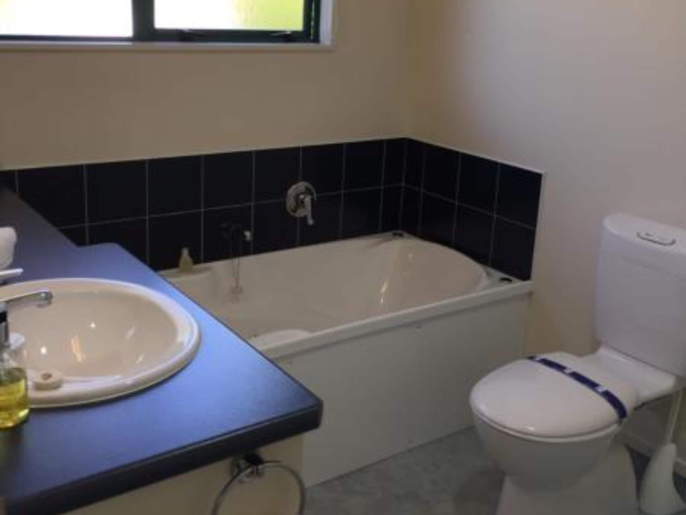 Un baño con bañera, inodoro y lavamanos.