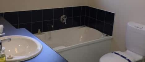 Un baño con bañera, inodoro y lavamanos.