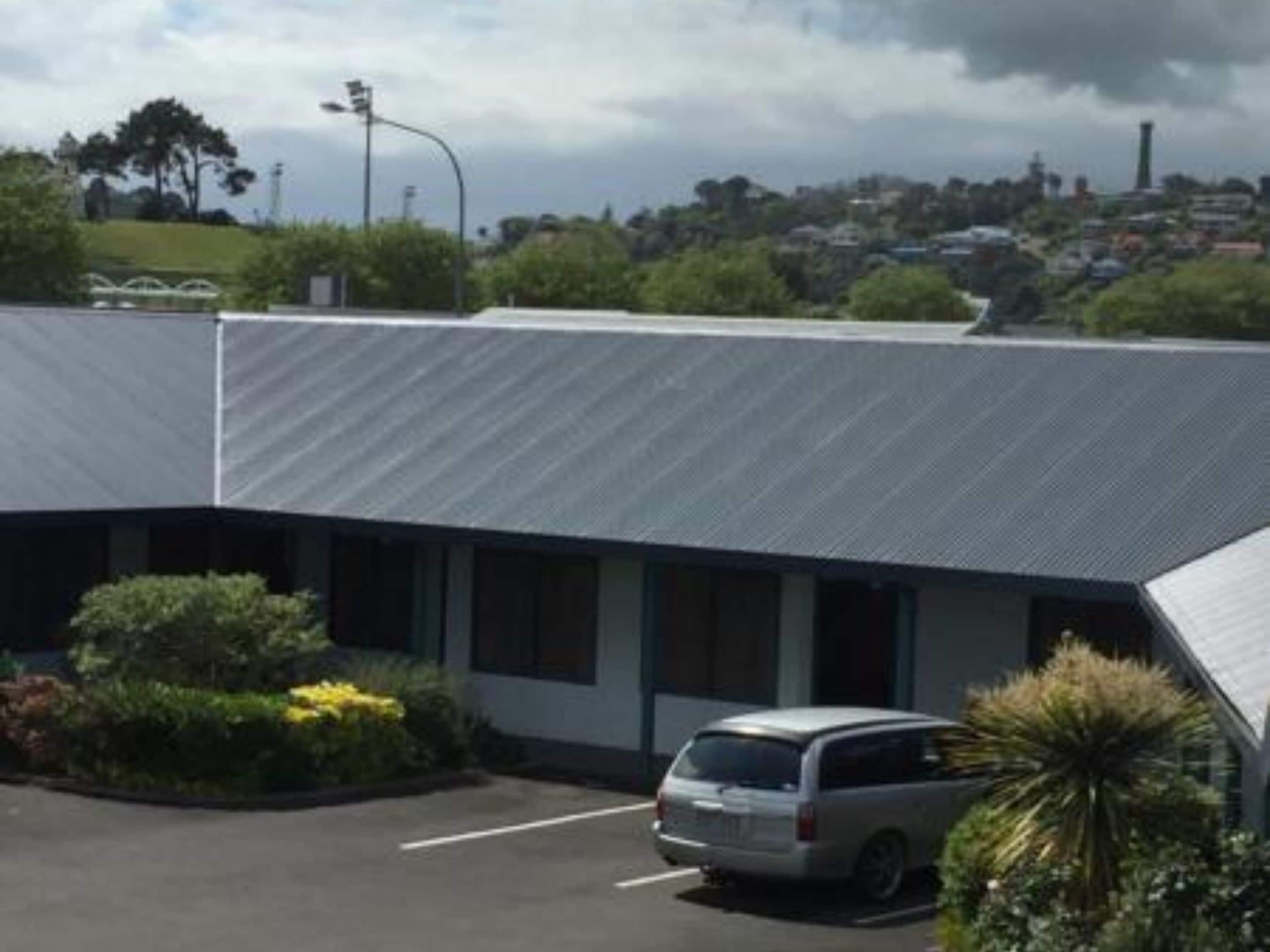 Un bâtiment avec un parking et un fourgon stationné.