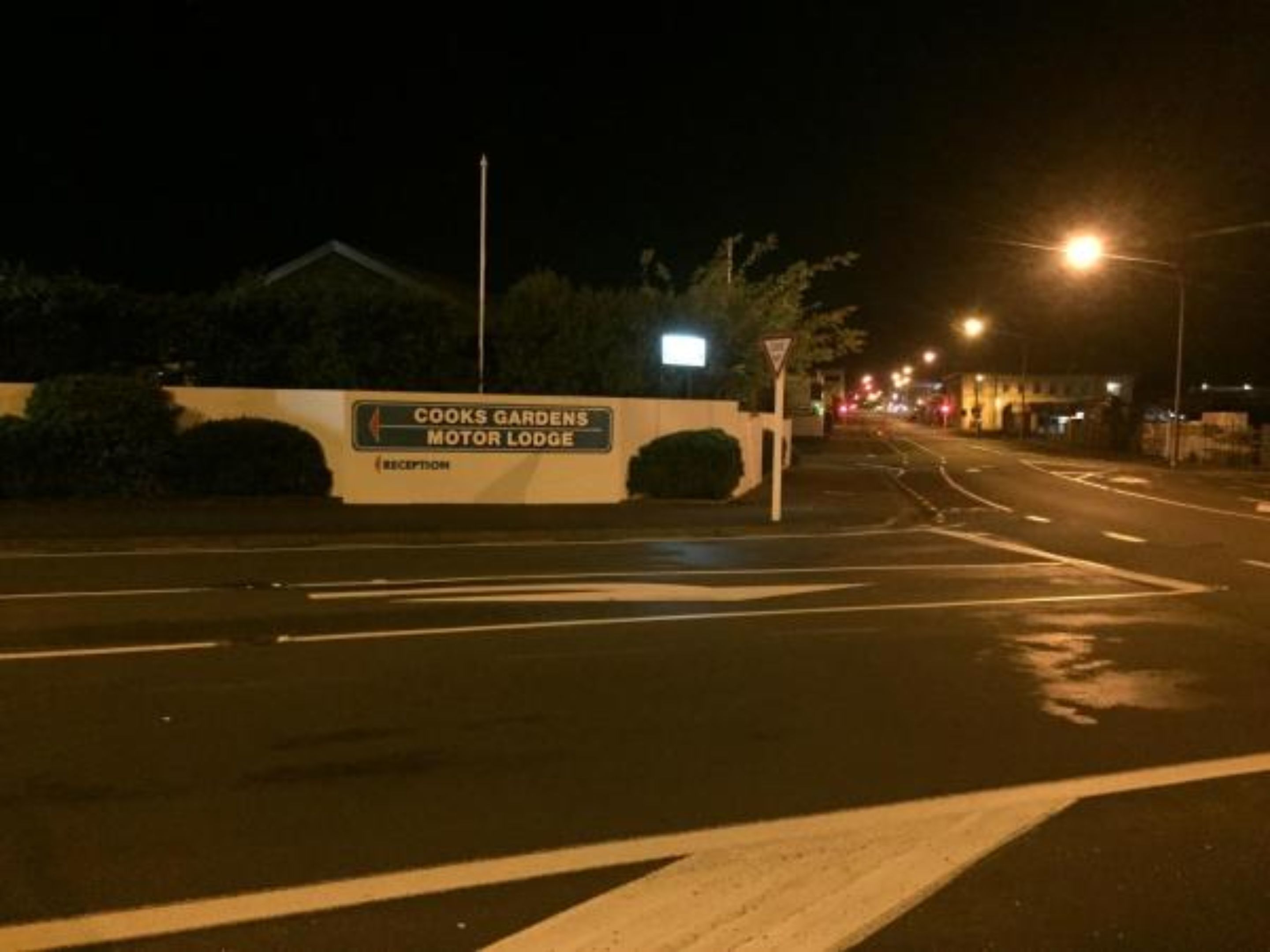 A sign for Coocks Gardens Motor Lodge with a reception area.