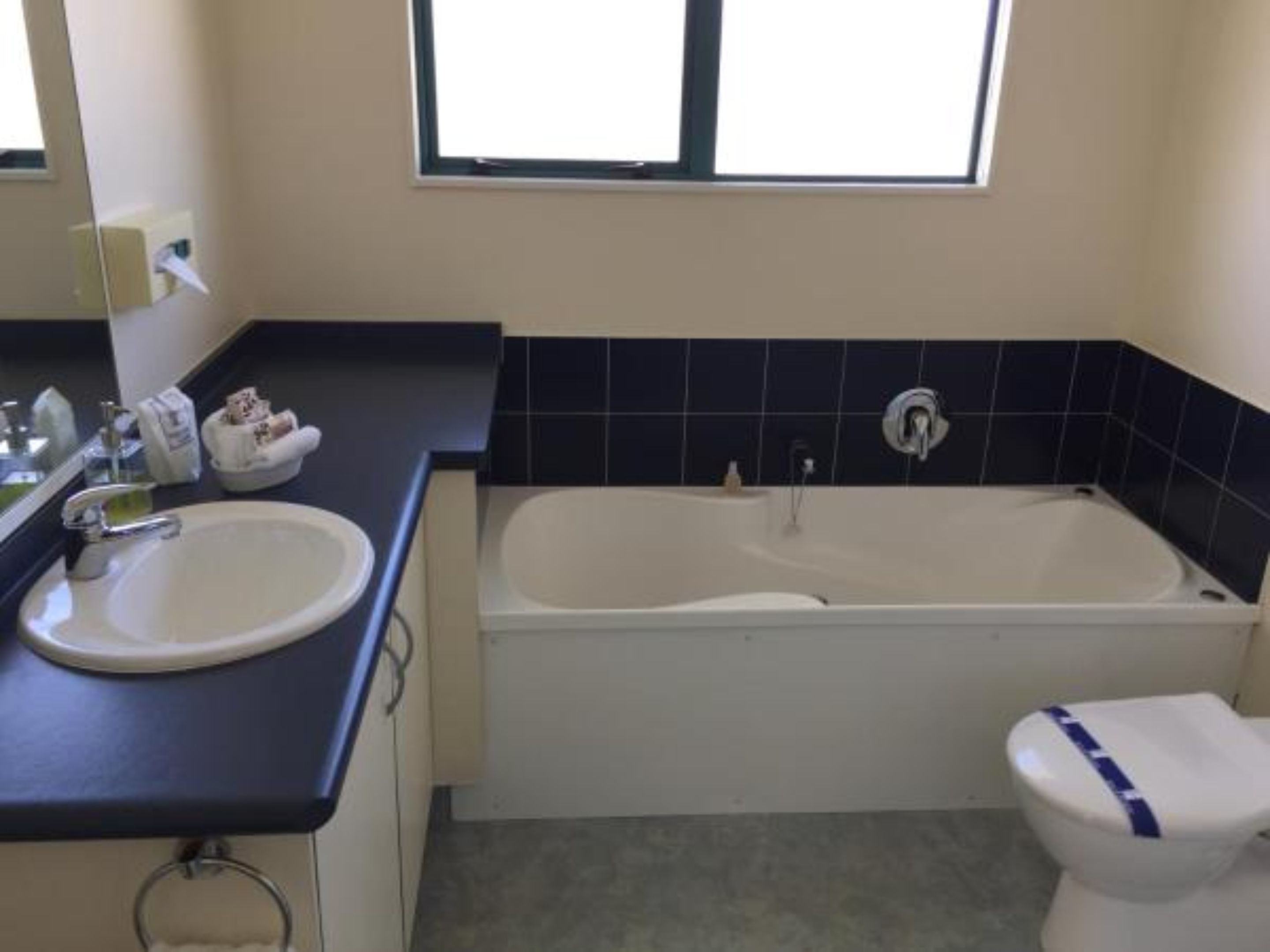 Un bany amb un lavabo blanc, una banyera i un vàter.