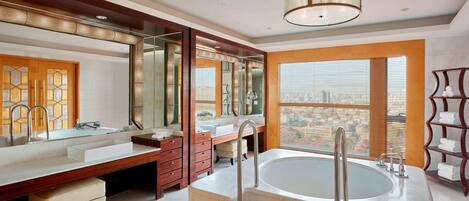 A modern bathroom with a large bathtub, double sinks, and a vanity with a mirror.