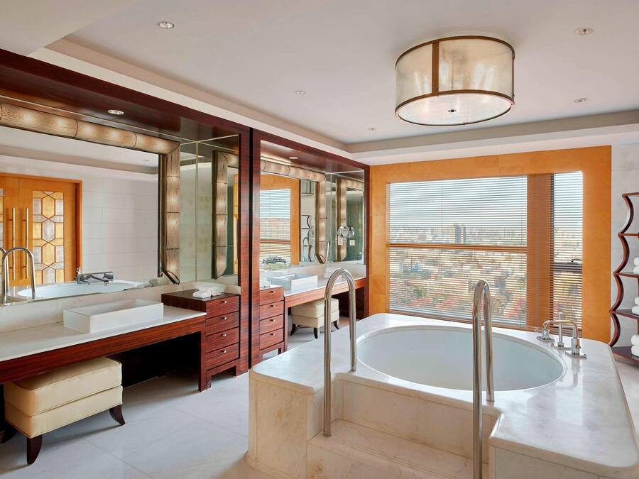 A modern bathroom with a large bathtub, double sinks, and a vanity with a mirror.