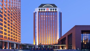 Un hôtel de grande hauteur, doté d’une façade à motifs géométriques de fenêtres, d’un logo bien visible sur le sommet et d’une architecture moderne.