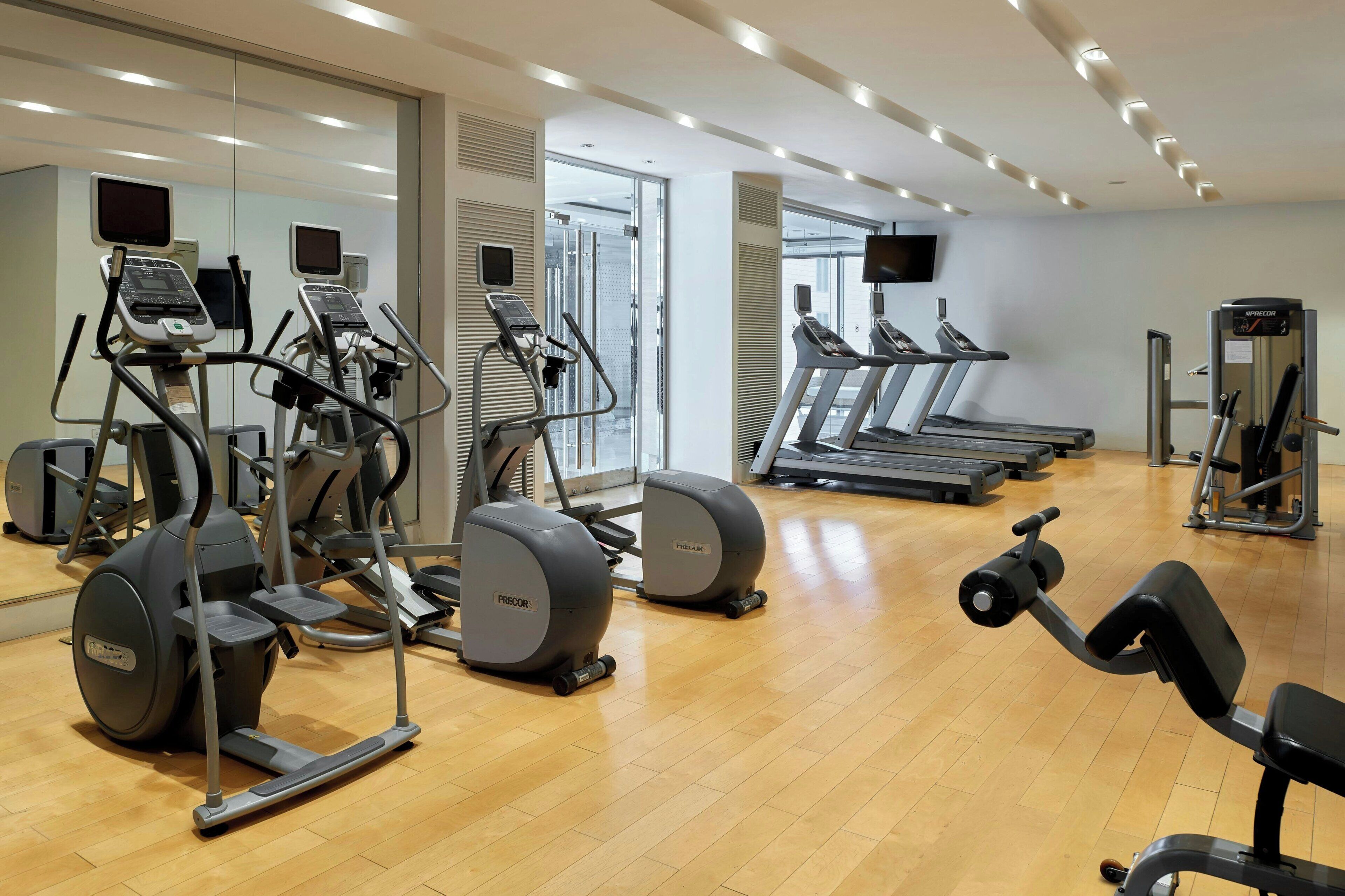 A gym with treadmills, elliptical machines, and weight equipment.