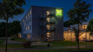 Un hôtel moderne, reconnaissable à son enseigne « ibis Styles » bien visible, doté de nombreux balcons et d’une entrée bien éclairée.