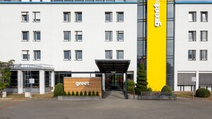Un bâtiment moderne, doté d’une enseigne bien visible avec le mot « bienvenue », d’une entrée abritée et d’une façade bien entretenue, agrémentée de fenêtres et d’un chemin en briques.
