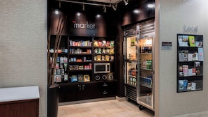 A market area with shelves stocked with snacks, a microwave, and a refrigerated display. - Courtyard by Marriott Tulsa Downtown (Tulsa)