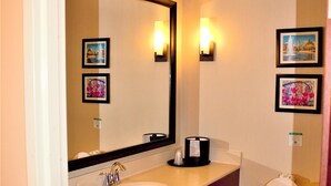 A bathroom with a double sink, a toilet, a large mirror, and two wall-mounted light fixtures. - Comfort Suites Huntersville near Lake Norman (Huntersville)