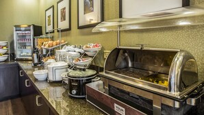 A buffet setup with various food items and a coffee station. - Comfort Suites Huntersville near Lake Norman (Huntersville)
