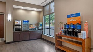A coffee station with multiple coffee dispensers, a refrigerated display case, and a sign indicating the coffee is from Seattle's Best.