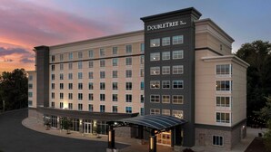 A large, multi-story hotel with a modern design, featuring a covered entrance and a parking area. - Doubletree by Hilton Chattanooga Hamilton Place (Chattanooga)