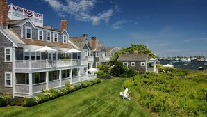 Une propriété située au bord de l’eau, comprenant une grande maison dotée d’un porche couvert et d’une petite maison d’hôtes.