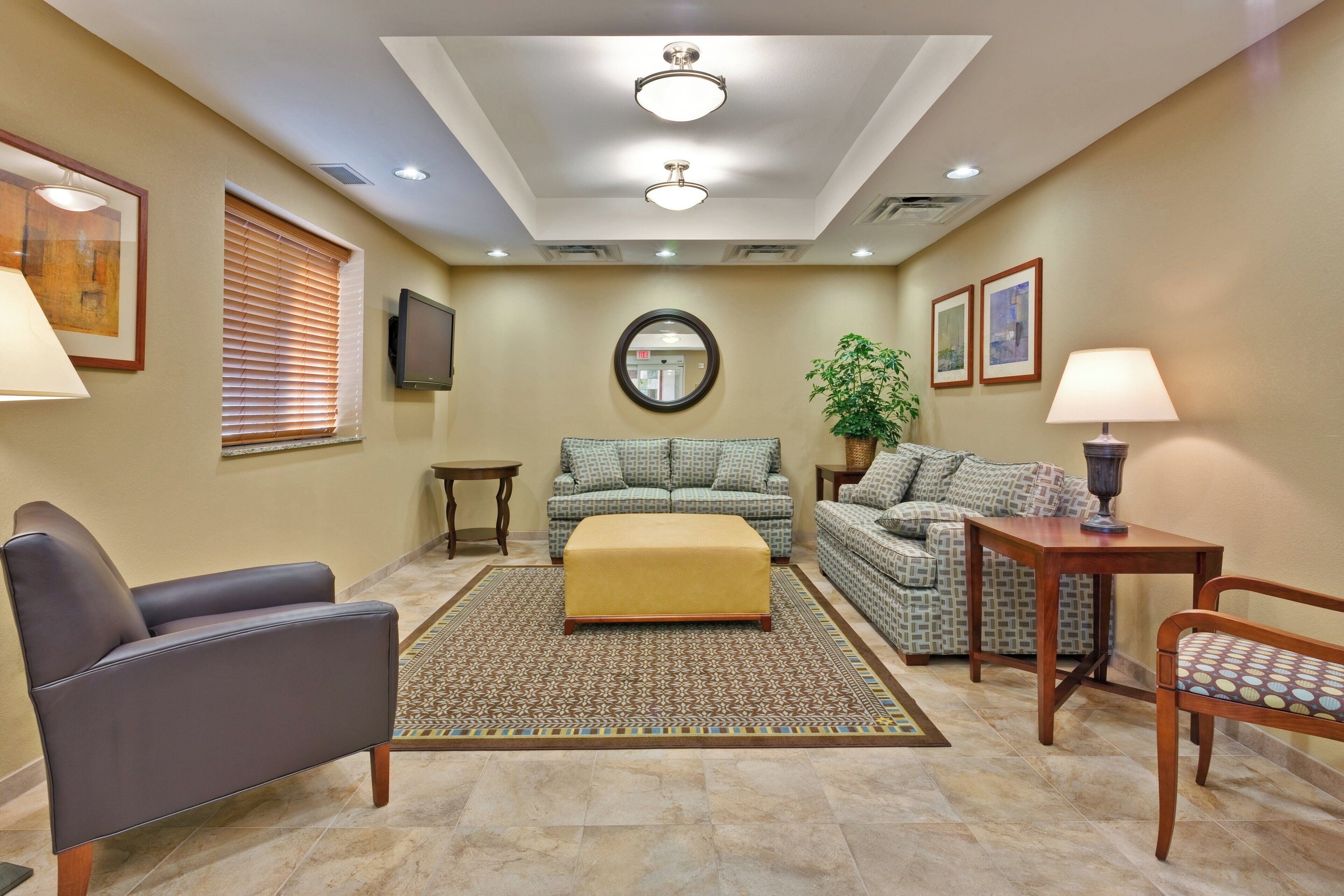 A living room with a sofa, ottoman, armchair, and a small table.