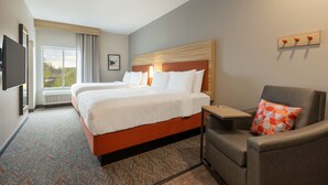 A hotel room with a large bed, a desk, a chair, and a TV mounted on the wall. - Candlewood Suites Murfreesboro by IHG (Murfreesboro)