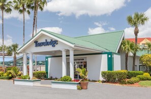 A Travelodge hotel with a green roof, registration area, and well-maintained landscaping. - Travelodge by Wyndham Lakeland (Lakeland)