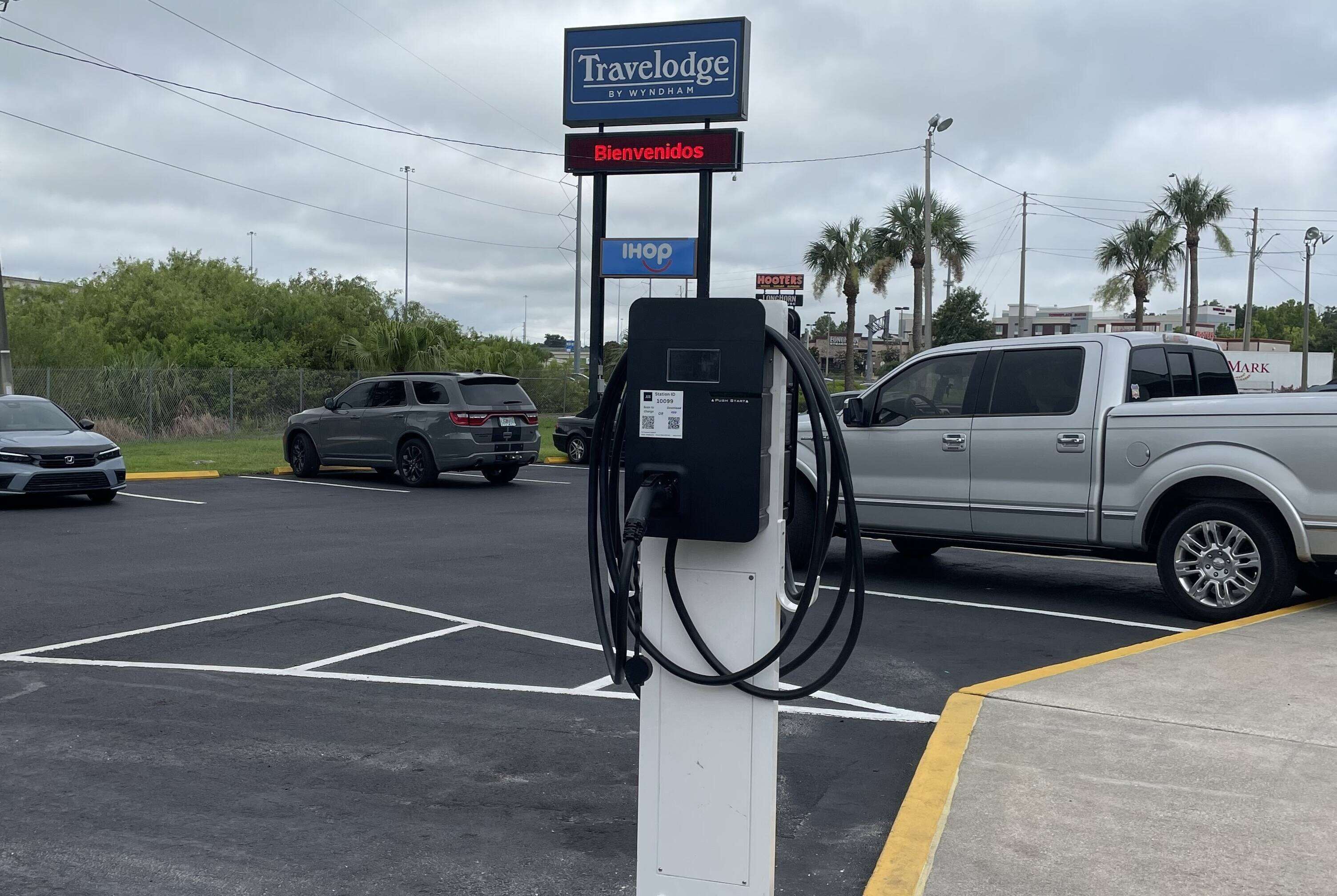 Un hotel de carretera con un letrero de 'Travelodge by Wyndham', un restaurante IHOP y una bomba de combustible.