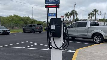 Un hotel de carretera con un letrero de 'Travelodge by Wyndham', un restaurante IHOP y una bomba de combustible.