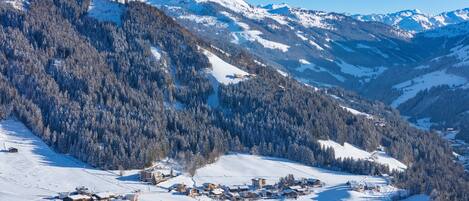Un village enneigé, avec des bâtiments et une montagne en arrière-plan.