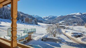 A hotel with a ski slope view, wooden architecture, and a sign indicating 'Hallenbad'. - Hotel Talhof (Wildschonau)