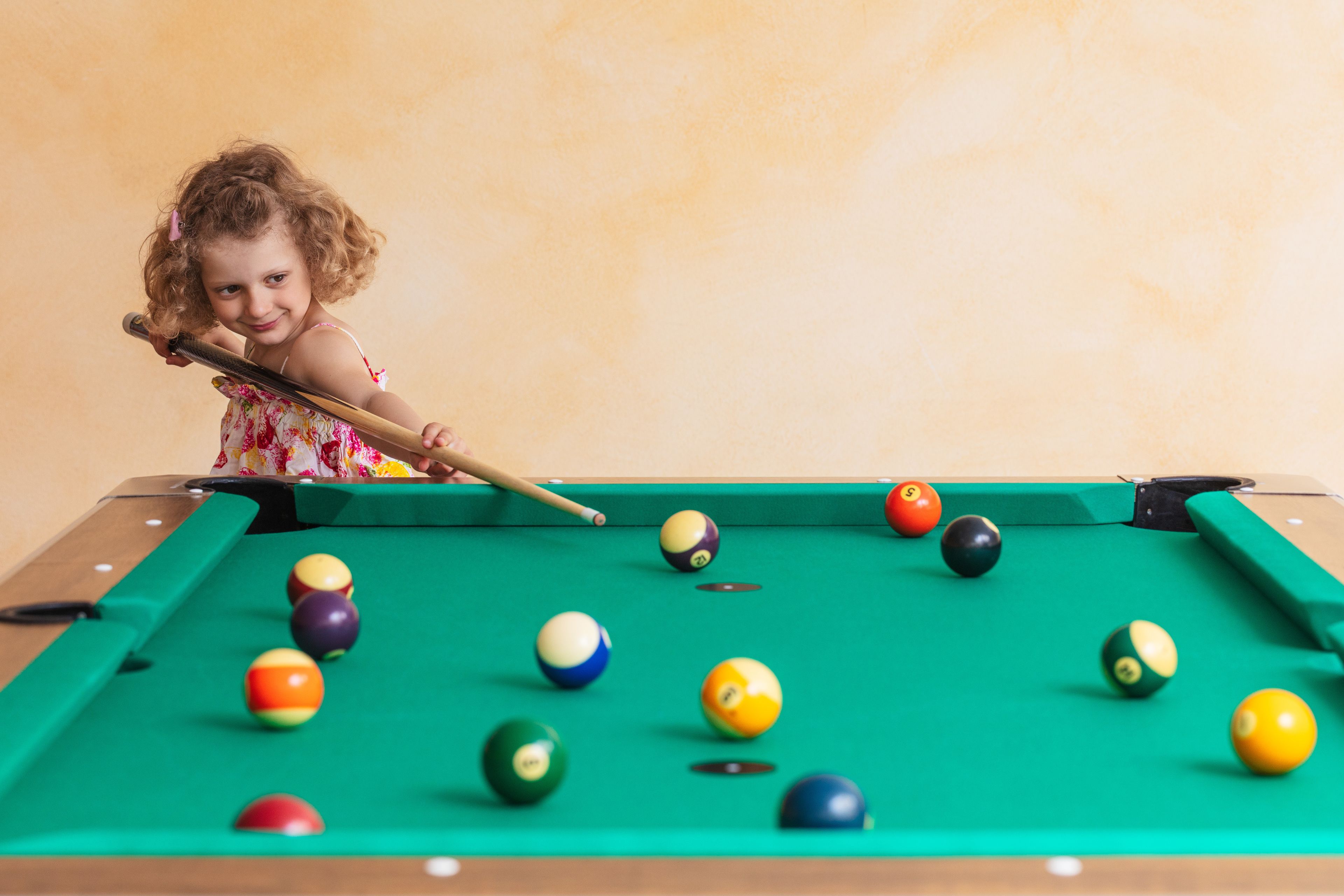 Une table de billard avec des billes de différentes couleurs et un queue de billard.