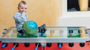 A child playing with a foosball table.