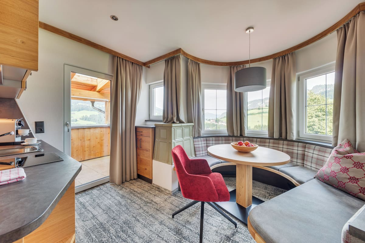 Una habitación acogedora con cocina, mesa de comedor y zona de estar con vistas al exterior.