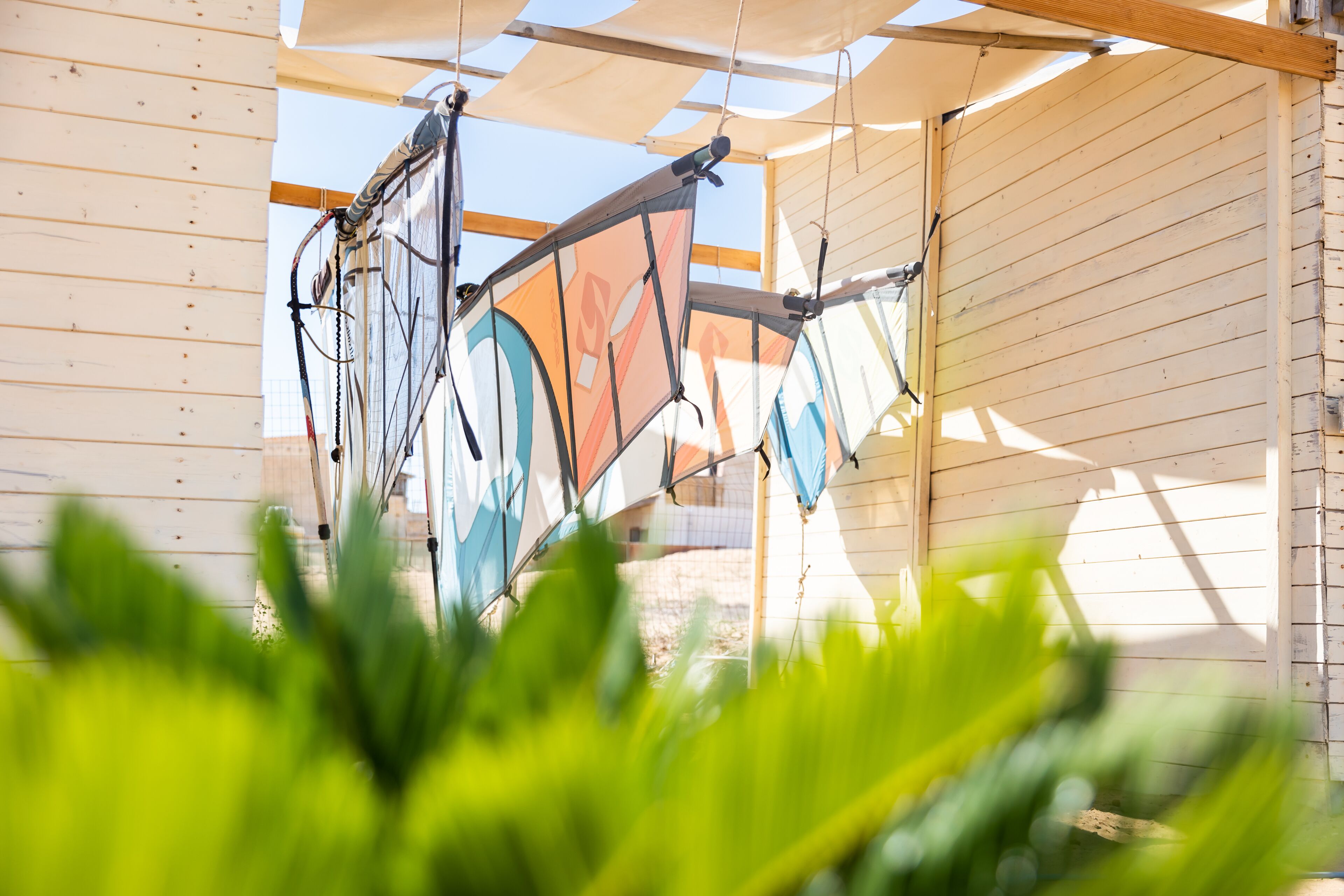 A covered outdoor area with a wooden structure and a sail-like canopy.