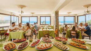 A dining area with multiple tables set for guests, featuring a variety of food platters. - Triscinamare Hotel Residence (Castelvetrano)