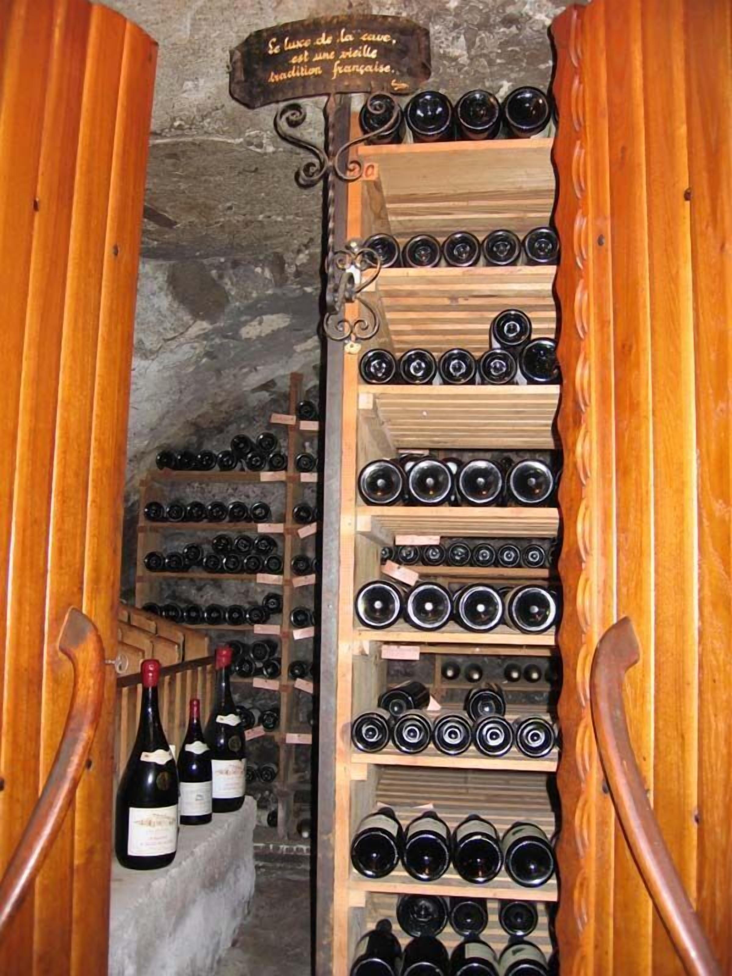 A wine cellar with wooden racks holding numerous wine bottles.