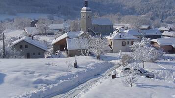 A snow-covered village with houses, a church, and a tower.