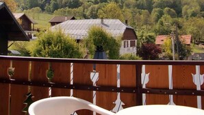 Un balcon avec vue sur une montagne et une vallée boisée.
